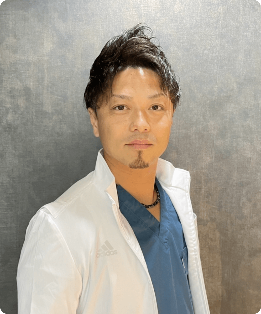 白衣を着た学院長の林孝太郎氏が穏やかに微笑んでいる姿