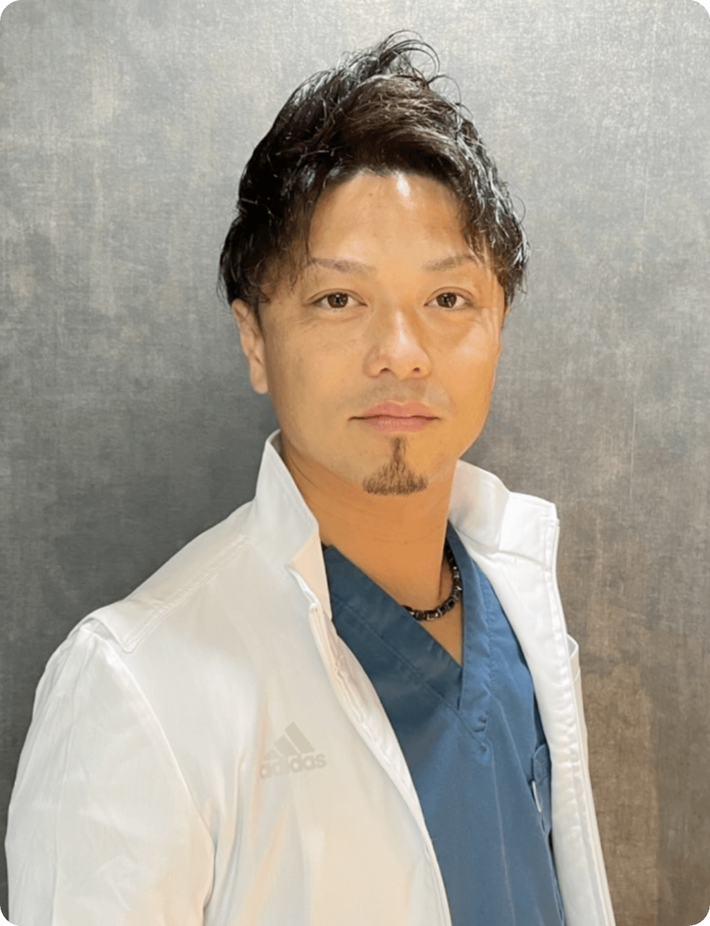 白衣を羽織った林孝太郎先生が正面を見つめるポートレート