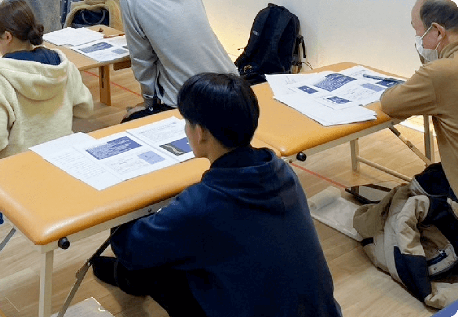 受講者たちはプリントやノートを見ながら講義を受けている。