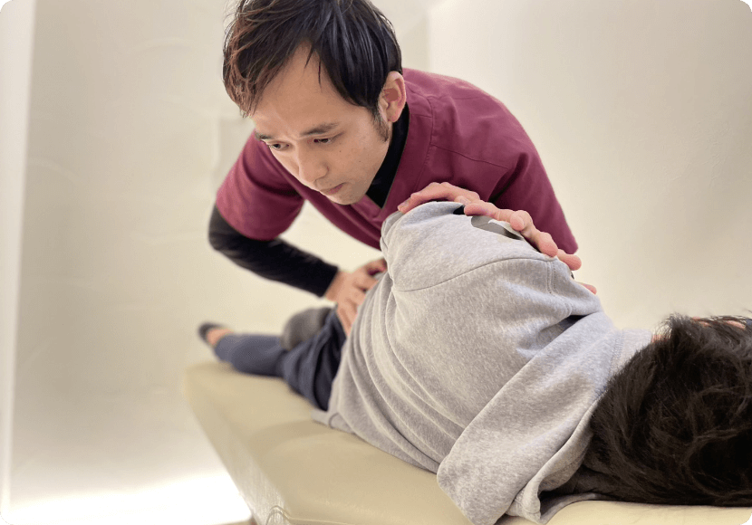 施術を受けている受講生とその動きを丁寧に指導する講師。